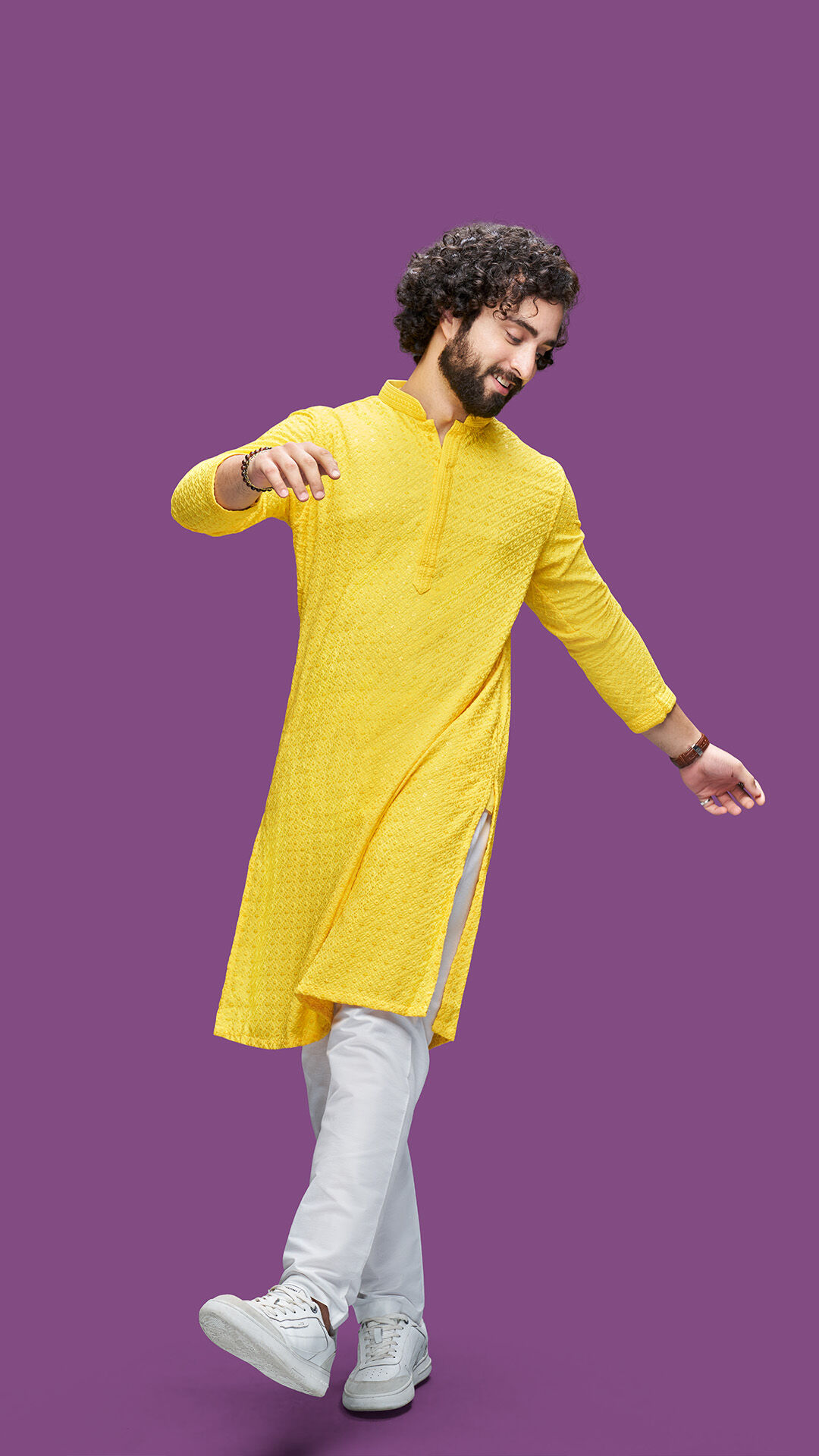 Man styling a mustard yellow kurta with white pajama and sneakers for modern festive fashion